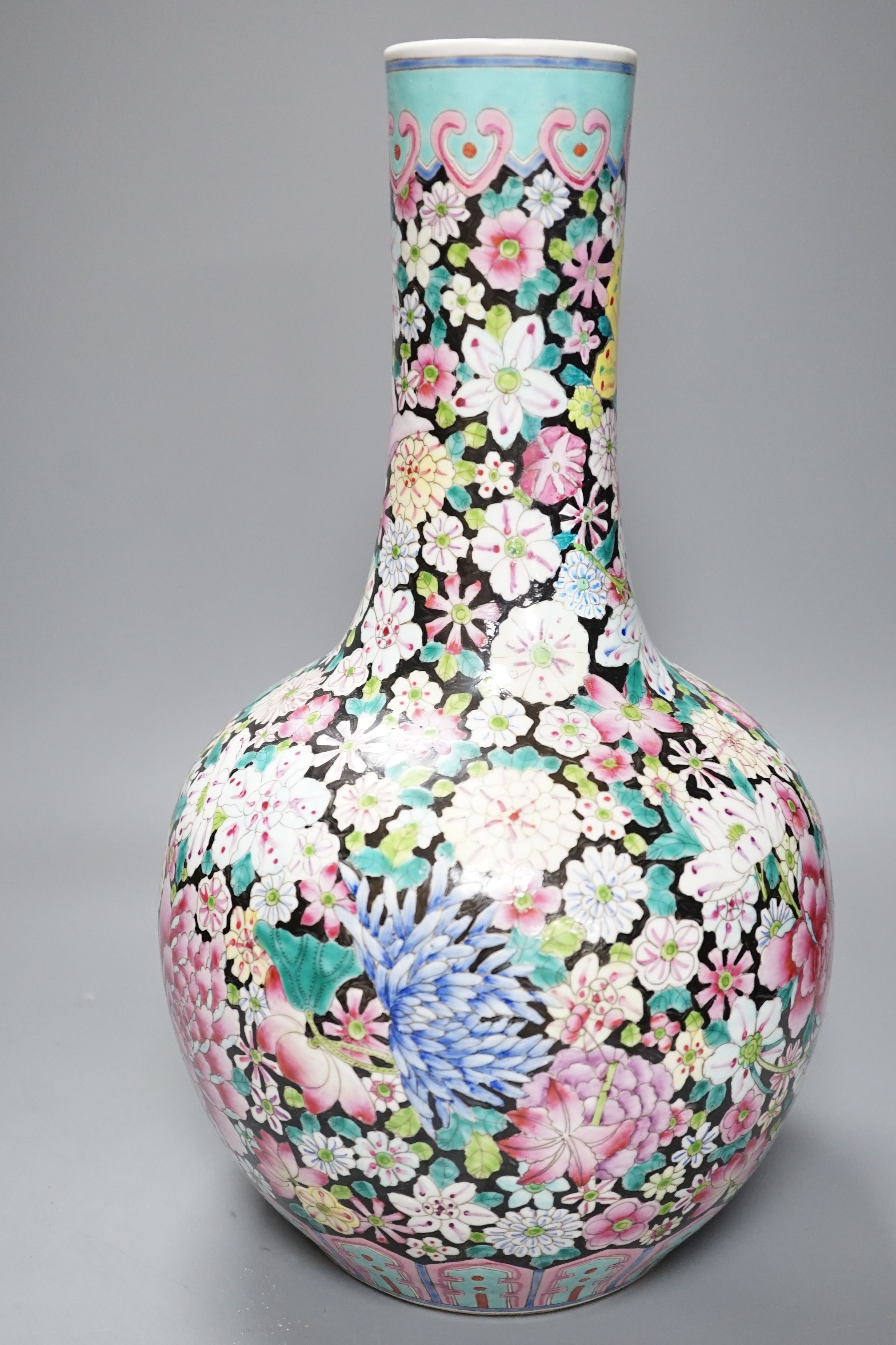 An early 20th century Chinese famille rose thousand flowers bottle vase (restored) together with a Chinese blue and white crackle glazed sleeve vase (a.f)., tallest 40cm